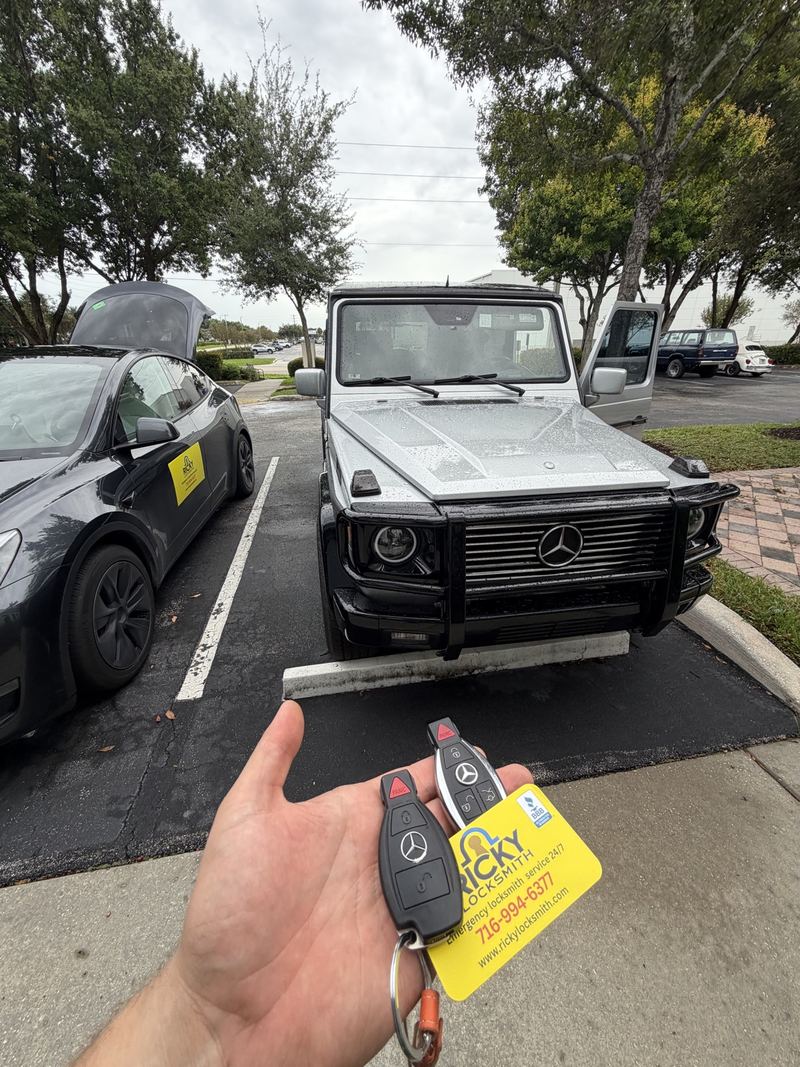 Two Mercedes-Benz keys held in front of a G-Class