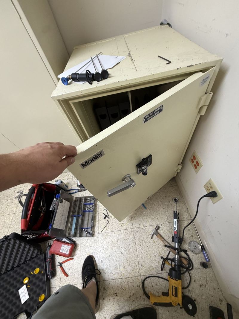 Open beige Mosler safe with tools nearby