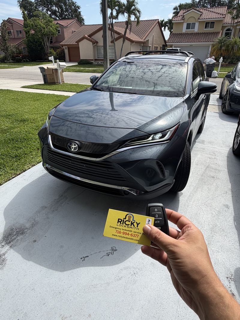 Toyota key and Ricky Locksmith card in front of a Toyota SUV